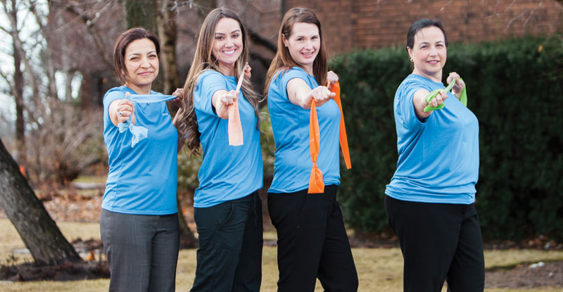 Lifemark employees holding exercise rubber band